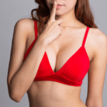 young sexy woman in red bra gesturing hush
