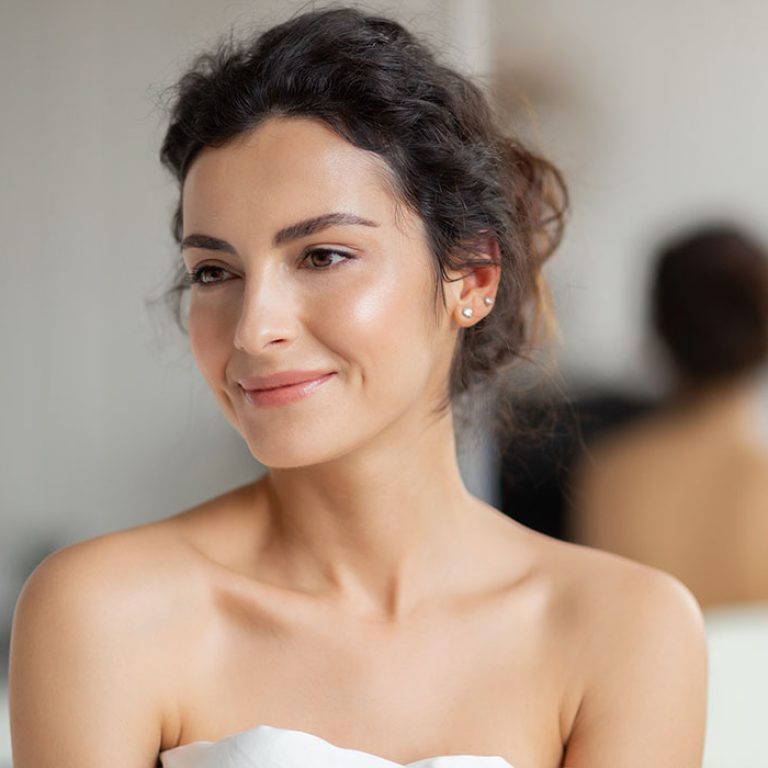Portrait  beautiful woman in bedroom. Headshot girl with natural beauty wrapped in blanket looking aside.